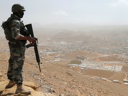 جندي لبنان يحمل سلاحه فوق تلة في بلدة عرسال قرب الحدود مع سوريا- 21 سبتمبر 2016 - REUTERS
