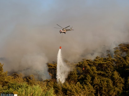 مروحية تحاول إخماد النيران خلال جهود إطفاء حرائق الغابات في مرمريس (جنوب غرب تركيا)- 31 يوليو 2021 - REUTERS