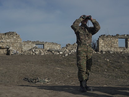 جندي أرميني ينظر من خلال منظار، وهو يقف في مواقع قتالية بالقرب من قرية تاغوارد في منطقة ناغورنو قره باغ. 11 يناير 2021 - REUTERS