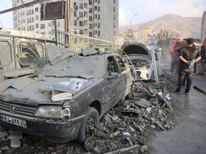 إيرانيون يتابعون آثار الدمار الناجم عن غارات إسرائيلة على طهران. 13 يونيو 2025 - via REUTERS