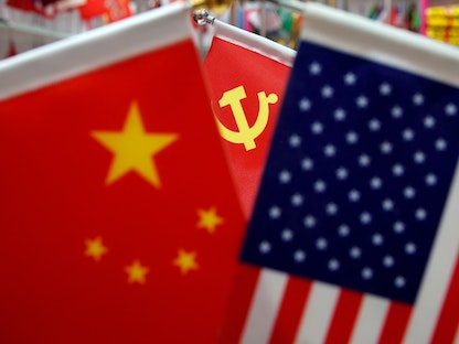 علما الولايات المتحدة الأميركية والصين ويظهر خلفهما علم الحزب الشيوعي الصيني - REUTERS