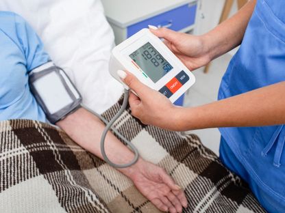 ممرضة تقيس ضغط الدم لأحد المرضى. 16 فبراير 2022 - AFP
