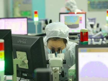 موظفة في أحد مصانع الرقائق الإلكترونية بالصين. 17 مارس 2021 - AFP