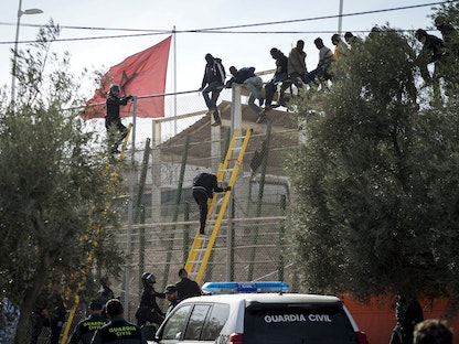 مهاجرون يتجاوزون السياج الحدودي الفاصل بين المغرب وجيب مليلية - 21 نوفمبر 2015 - REUTERS