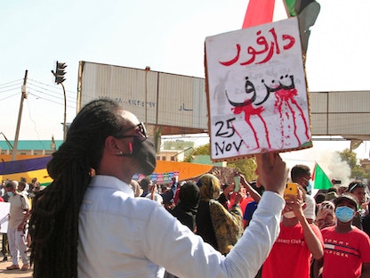 سوداني يحمل لافتة مكتوباً عليها "دارفور تنزف" خلال مظاهرة في أم درمان بالعاصمة الخرطوم. 13 ديسمبر 2021 - AFP