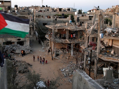 علم فلسطين يرفرف على أنقاض المنازل التي دمرتها الغارات الإسرائيلية في الحرب الأخيرة على غزة- 25 مايو 2021 - REUTERS