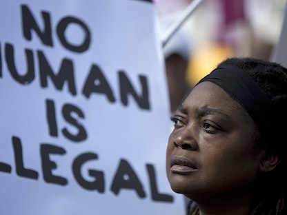 امرأة تقف أمام لافتة خلال مسيرة ضد العنصرية في وسط العاصمة البريطانية لندن. 22 مارس 2014 - Reuters