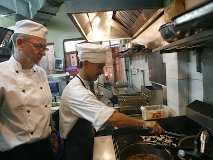 طاه يراقب طباخاً متدرباً في مطعم بهانوي عاصمة فيتنام. 8 يونيو 2007 - REUTERS