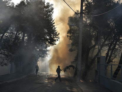 حريق يشتعل في منطقة ثراكوماكدونيس شمال العاصمة اليونانية أثينا، 7 أغسطس 2021 - AFP
