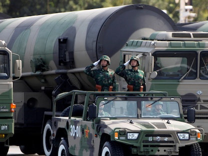 جنود صينيون يؤدون التحية بجانب صواريخ قادرة على حمل أسلحة نووية خلال عرض عسكري في بكين- 1 أكتوبر 2009 - REUTERS