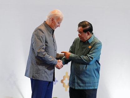 الرئيس الأميركي جو بايدن ورئيس وزراء كمبوديا هون سين يتصافحان أثناء حضورهما حفل عشاء قمة شرق آسيا في بنوم بنه - 12 نوفمبر 2022 - REUTERS