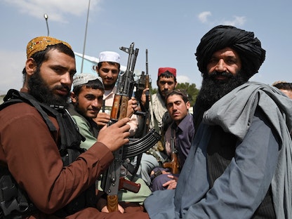 مقاتلو طالبان يجلسون على ظهر شاحنة صغيرة في مطار كابول، 31 أغسطس 2021  - AFP