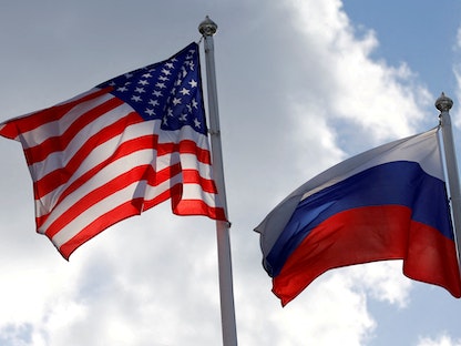 علما روسيا وأميركا يرفرفان بالقرب من مصنع في فسيفولوزك بمنطقة لينينغراد في روسيا،27 مارس2019.  - REUTERS