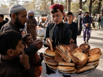 فتى يبيع الخبز لأسر أفغانية نازحة في حديقة شهر ناو في كابول. أفغانستان، 4 أكتوبر 2021 - REUTERS