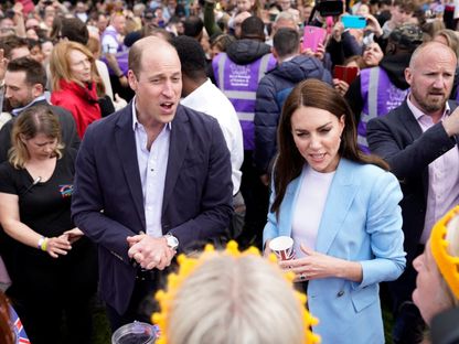 أمير وأميرة ويلز يتحدثان مع بعض الأشخاص بالقرب من قلعة وندسور بيركشاير حيث يقام حفل تتويج الملك تشارلز الثالث والملكة كاميلا. 7 مايو 2023 - Reuters