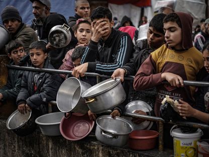 أطفال فلسطينيون ينتظرون دورهم في الحصول على الطعام الذي أعده متطوعون في رفح جنوب غزة. 10 فبراير 2024 - AFP