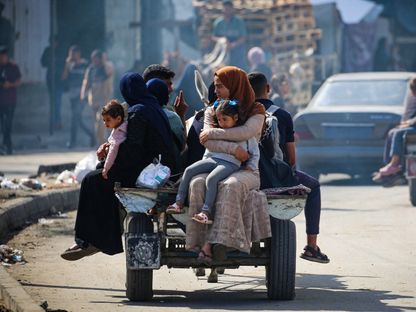 أسرة فلسطينية تغادر شرق رفح بعدما شن الجيش الإسرائيلي هجوماً جوياً ومدفعياً على مناطق متفرقة من المدينة في جنوب القطاع. 7 مايو 2024 - AFP