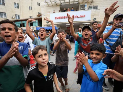 أطفال فلسطينيون أمام مستشفى "شهداء الأقصى" بدير البلح شمال قطاع غزة يحتفلون باتفاق وقف إطلاق النار في القطاع. 9 أكتوبر 2025 - REUTERS