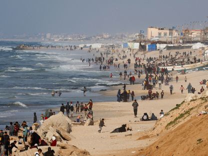فلسطينيون يحتشدون على الشاطئ أملا في الحصول على مساعدات تسقطها طائرات على غزة. 27 فبراير 2024 - رويترز