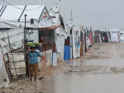 طفل فلسطيني نازح يسير وسط مياه الأمطار في مخيم بمدينة خان يونس. جنوب قطاع غزة. 11 ديسمبر 2025 - reuters