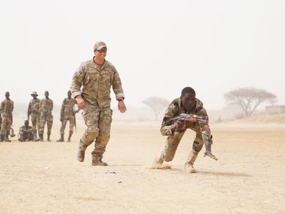 ضابط بالجيش الأميركي يتابع جندي بالجيش النيجري خلال تدريبات عسكرية في ديفا بالنيجر. 11 مارس 2017. - AFP