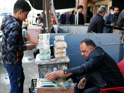 أحد تجار العملة داخل سوق لصرف العملات الأجنبية في العاصمة العراقية بغداد. 20 ديسمبر 2020 - REUTERS