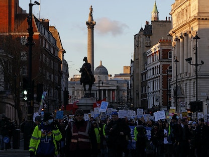أشخاص يحملون لافتات أثناء إضراب ممرضات وغيرهم من العاملين الطبيين في لندن، بريطانيا- 18 يناير 2023 - AFP
