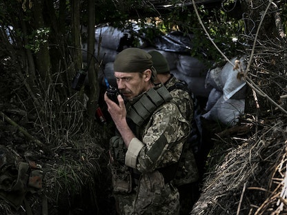 جندي أوكراني يتحدث في جهاز اللاسلكي على خط المواجهة الأمامي في إقليم دونباس بشرق البلاد. 10 يونيو 2022 - AFP