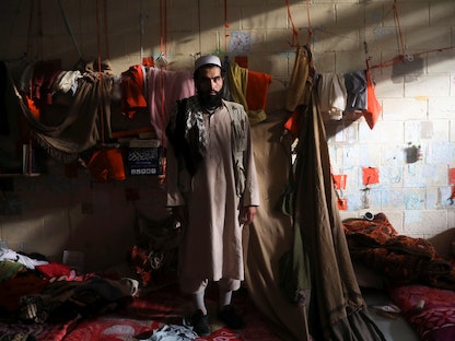 تاجر سجاد أفغاني أمام بضائع معروضة - REUTERS