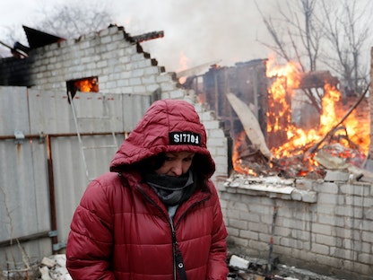 امرأة أمام منزلها الذي اشتعلت فيه النيران بعد القصف الأخير على دونيتسك التي يسيطر عليها الانفصاليون - أوكرانيا -28 فبراير 2022 - REUTERS