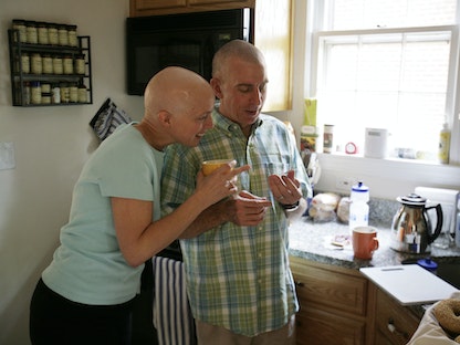 مريضة بالسرطان وزوجها يلقيان نظرة على بطاقة إرشادية للمصابات بسرطان الثدي في مطبخ منزلهم بولاية واشنطن الأميركية. 25 مايو 2007 - REUTERS