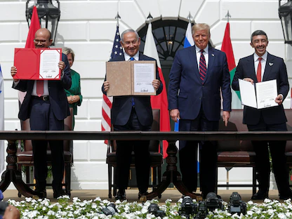 وزير الخارجية الإماراتي عبد الله بن زايد (يميناً) ورئيس الوزراء الإسرائيلي السابق بنيامين نتنياهو ووزير الخارجية البحريني عبد اللطيف الزياني يعرضون نسخهم الموقعة من "اتفاقات أبراهام" بحضور الرئيس الأميركي السابق دونالد ترمب في البيت الأبيض، 15 سبتمبر 2020  - REUTERS