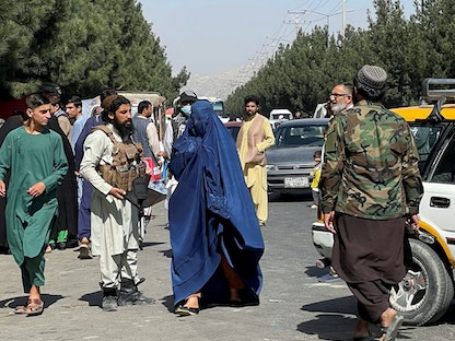 امرأة تمر أمام قوات طالبان في أحد شوارع كابول 27 أغسطس 2021 - REUTERS