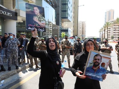أفراد عائلات بعض ضحايا انفجار مرفأ بيروت يحملون صورهم خلال مظاهرة للمطالبة بالعدالة، في بيروت، لبنان. 9 يوليو 2021 - REUTERS