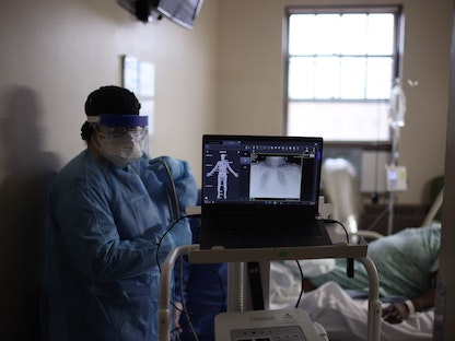 ممرضة بمستشفى روزلاند كوميونيتي في شيكاغو تعالج مصاباً بفيروس كورونا، 15 ديسمبر 2020 - AFP