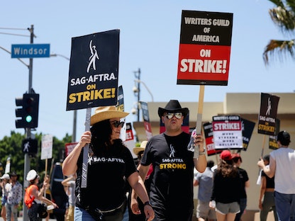 ممثلو نقابة الممثلين ونقابة الكتاب الأمريكية أثناء إضرابهم خارج استوديوهات "باراماونت" في لوس أنجلوس، كاليفورنيا، الولايات المتحدة، 2 أغسطس 2023. - REUTERS