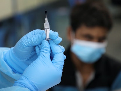 عامل طبي يحضّر جرعة من لقاح كورونا لتطعيم أحد الأشخاص في ماليزيا- 8 يوليو 2021 - REUTERS