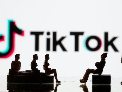 مجسمات لشخصيات صغيرة أمام شعار "Tiktok" في 9 سبتمبر 2020.  - REUTERS