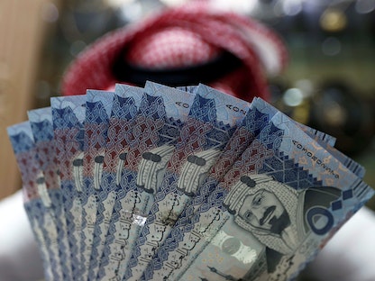 صراف سعودي يعرض عملات ورقية بالريال السعودي في أحد متاجر الصرافة في الرياض - REUTERS