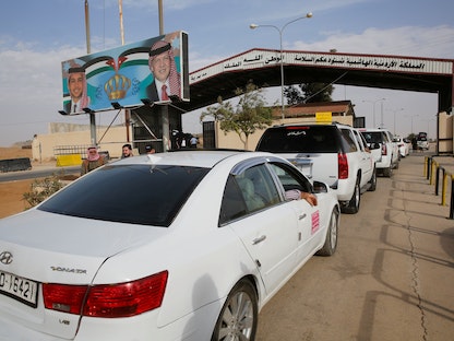 عناصر من الأمن الأردني يفتشون السيارات المتجهة إلى سوريا عبر معبر جابر - REUTERS