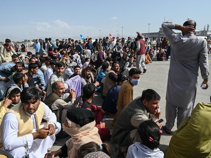 مواطنون أفغان ينتظرون مغادرة مطار كابول، 16 أغسطس 2021 - AFP