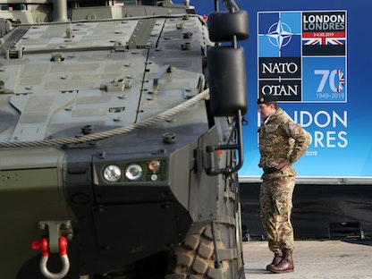 جندي بريطاني يقف أمام عربة مدرعة تابعة لحلف الناتو في واتفورد - بريطانيا - 3 ديسمبر 2019 - REUTERS