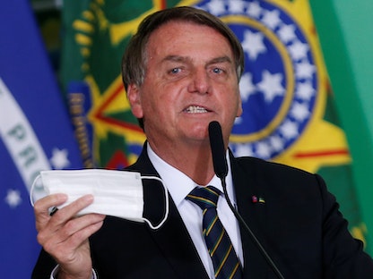 الرئيس البرازيلي جايير بولسونارو يحمل كمامته خلال حفل أقيم في قصر بلانالتو الرئاسي وسط جائحة كورونا في برازيليا - 10 يونيو 2021 - REUTERS