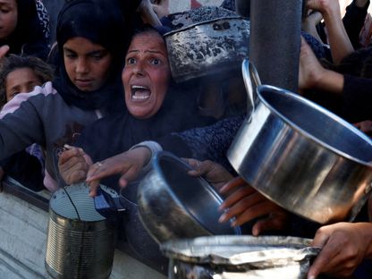 نساء وفتيات فلسطينيات ينتظرن الحصول على الطعام بأحد مراكز التوزيع في خان يونس جنوبي قطاع غزة. 4 ديسمبر 2024 - REUTERS