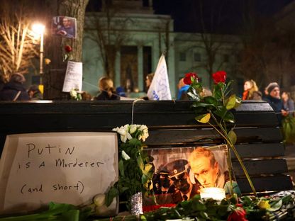 زهور وشموع بجوار صورة زعيم المعارضة الروسية الراحل أليكسي نافالني في أمام السفارة الروسية في برلين، ألمانيا. 23 فبراير 2024 - REUTERS