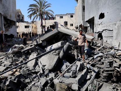 فلسطينيون يتفقدون الأضرار في موقع غارة إسرائيلية على منازل في دير البلح وسط قطاع غزة. 23 أغسطس 2025 - REUTERS