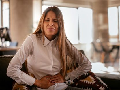 امرأة تعاني من آلام في المعدة - Getty Images