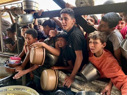 أطفال فلسطينيون في مدينة رفح بقطاع غزة يتزاحمون  من أجل الحصول على الطعام. 3 مايو 2024 - AFP