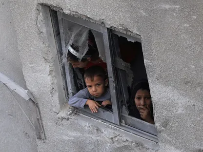 أطفال فلسطينيون ينظرون من نافذة بالقرب من منزل تضرر في غارة إسرائيلية على مدينة غزة. 29 أكتوبر 2025 - رويترز