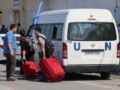 فلسطينيون يحملون جوازات سفر أجنبية يصلون إلى الجانب الفلسطيني من معبر رفح للعبور إلى مصر مع استمرار الهجمات الإسرائيلية على قطاع غزة. 14 أكتوبر، 2023. - AFP